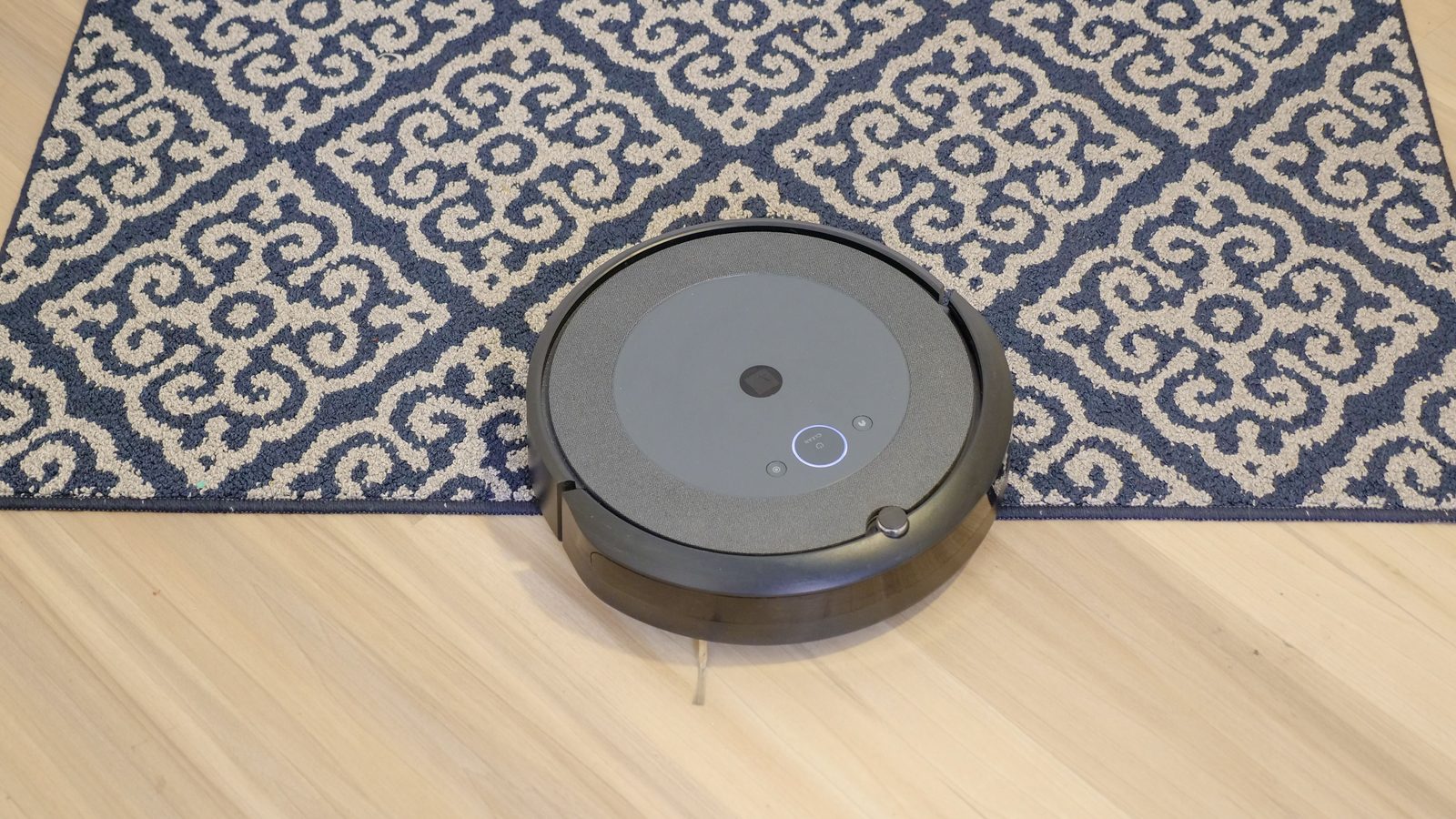 Robotstøvsuger kører fra trægulv op på en tæppekant